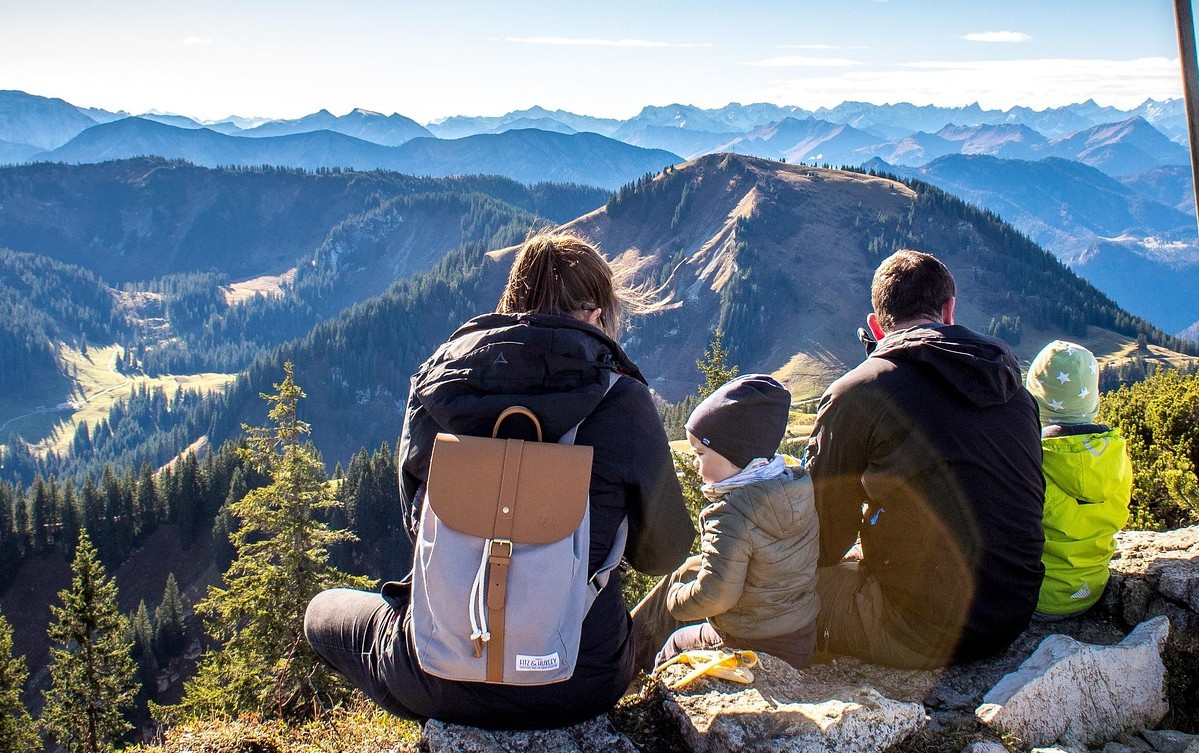 Family sitting together on a mountain overlook enjoying the vista