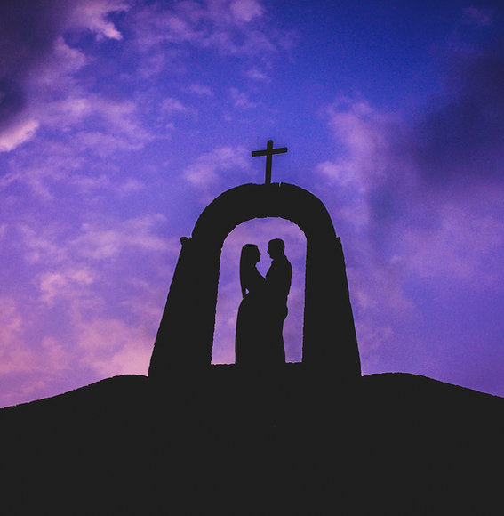 Silhouette of a couple standing together beneath a cross at sunset, symbolizing a Christ-centered covenant marriage